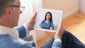 Elderly Man Having Video Call With Doctor, Using Digital Tablet At Home Royalty Free Stock Photo