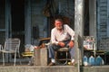 An elderly man on his front porch,