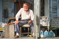 An elderly man on his front porch,