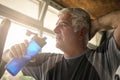 Elderly man holding a bottle of water. The man is refreshed