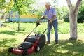 Cheerful mature man with lawnmower on a farm Royalty Free Stock Photo