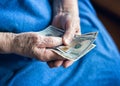 Elderly man holding money in his hand