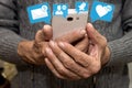 Elderly man holding smartphone with icons of notifications from social media. Social media for the elderly concept. Chat with love