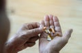 An elderly man holds a lot of colored pills in old hands. Painful old age Royalty Free Stock Photo