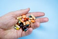 Tablets and pills on the palm of a person. An elderly man holds a lot of colored pills in old hands. Painful old age Royalty Free Stock Photo