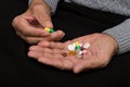 An elderly man holds a lot of colored pills in old hands. Painful old age. Health care of older people Royalty Free Stock Photo