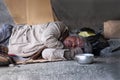 Elderly man homeless dirty with gray hair wear sweater and glasses sleeping on cardboard box to beggar and ask for help in shelter Royalty Free Stock Photo