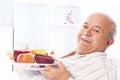 Elderly man in a hospital bed eating Royalty Free Stock Photo