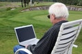 Elderly man with laptop at golf course Royalty Free Stock Photo