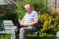 An elderly man with laptop outside. Royalty Free Stock Photo