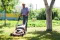 Elderly man with a lawn mower while mowing the lawn Royalty Free Stock Photo
