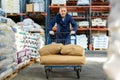 Elderly man loader with cargo cart loaded with bags