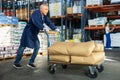 Elderly man loader with cargo cart loaded with bags