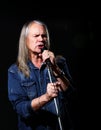 Elderly man with long gray hair sings into a microphone Royalty Free Stock Photo