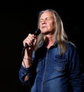 Elderly man with long gray hair sings into a microphone Royalty Free Stock Photo