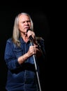 Elderly man with long gray hair sings into a microphone Royalty Free Stock Photo