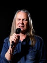 Elderly man with long gray hair sings into a microphone Royalty Free Stock Photo