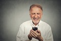 Elderly man looking at his smart phone while text messaging Royalty Free Stock Photo