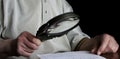 Elderly man looking at object with magnifier