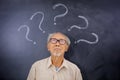 Elderly man looking at question marks Royalty Free Stock Photo