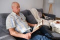 An elderly man looks through an album with old photographs, a concept of memories of youth, childhood, remembering his life, Royalty Free Stock Photo