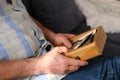 An elderly man looks through his old photographs of 1960-1965, the concept of nostalgia and memories of youth, childhood, Royalty Free Stock Photo