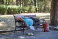 An elderly man lying barefoot on a bench in the city park and sleeping in the middle of the day in Burgas/Bulgaria/08/14/2016.