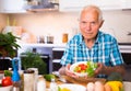 elderly man made a fresh vegetable salad at home Royalty Free Stock Photo