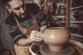 Elderly man making pot using pottery wheel in studio Royalty Free Stock Photo