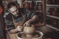 Elderly man making pot using pottery wheel in studio Royalty Free Stock Photo