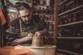 Elderly man making pot using pottery wheel in studio Royalty Free Stock Photo