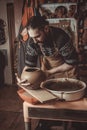 Elderly man making pot using pottery wheel in studio Royalty Free Stock Photo