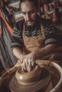 Elderly man making pot using pottery wheel in studio Royalty Free Stock Photo