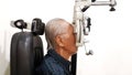 Elderly man measuring his eyesight with phoropter