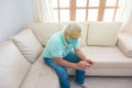 An elderly man in a medical mask sending a text message on his mobile phone at home Royalty Free Stock Photo