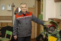 An elderly man in overalls near an old lathe. Teacher of labor lessons in a Russian school