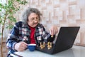 An elderly man playing chess at home on the computer Royalty Free Stock Photo