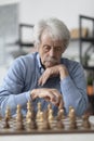 Elderly man playing chess at home Royalty Free Stock Photo