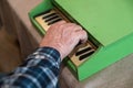 An elderly man plays a toy piano. His right hand is playing a jolly tune on an old children`s musical instrument Royalty Free Stock Photo