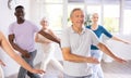 Elderly man practicing vigorous dance during group class