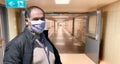 Elderly man in protective medical mask isolated against empty hospital corridor. Coronavirus elderly advice. Safety old men.