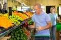 Elderly man purchaser buying pepper in grocery store