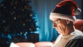 Elderly Man Reading Book On Christmas sofa in the house Royalty Free Stock Photo