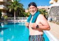 An elderly man ready to play sports and swim in the blue pool. Man with white beard and mustache with swimming cap and goggles. A Royalty Free Stock Photo