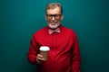 Elderly man in red shirt with bow-tie hold coffee Royalty Free Stock Photo