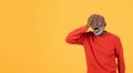 Elderly man in red sweater and hat holding his head with an agonized expression Royalty Free Stock Photo