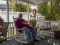 Elderly man relaxing on a rocking chair on a porch Royalty Free Stock Photo