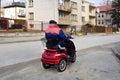An elderly man rides around the city on a modern mechanical wheelchair. Helping weak people in everyday life. The movement of