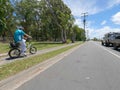 elderly man riding electric bicycle along path on sunny day