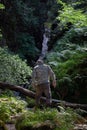 Elderly man after a rock climb watching and exploring waterfall in Wicklow Mountains in sunny day, Wicklow Mountains, Ireland